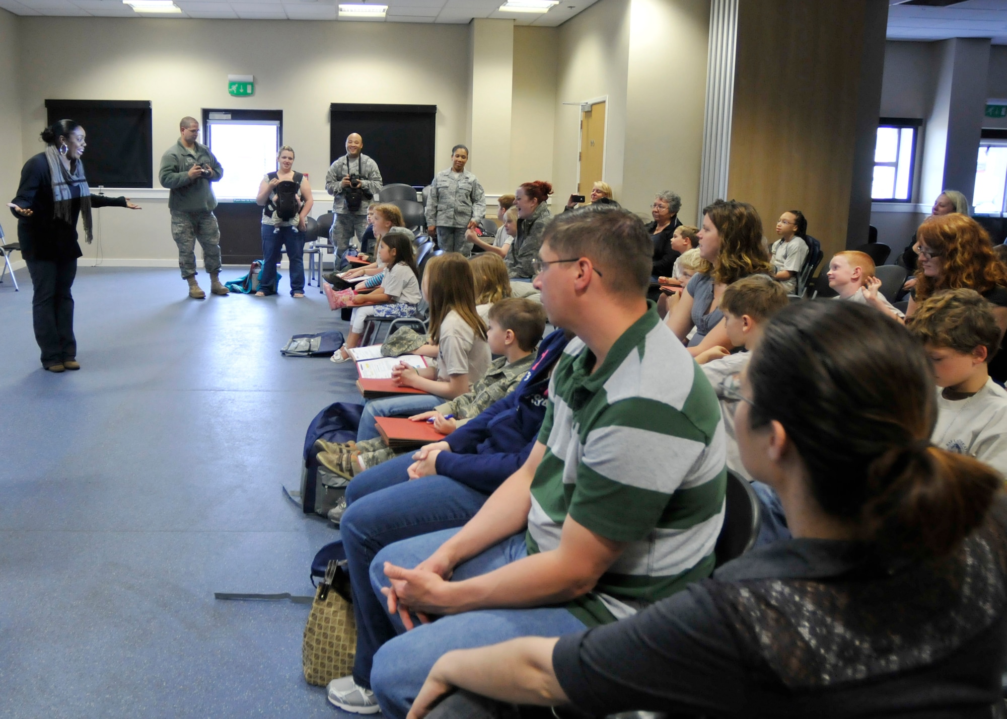 ROYAL AIR FORCE LAKENHEATH, England - Javonika McCree, 48th Force Support Squadron Airman and Family Readiness Center community readiness consultant, briefs parents and children during a simulated deployment line at the Installation Deployment Readiness Center, Aug. 25, 2011. The mock deployment line is designed to provide children with a better understanding of what their parents experience as they prepare for deployment. (U.S. Air Force photo/Senior Airman Tiffany M. Deuel)