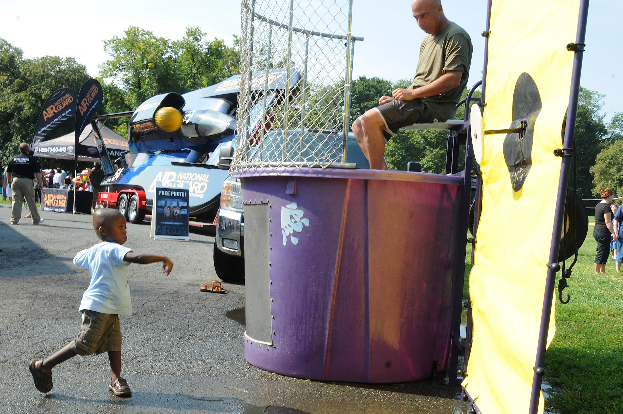Chief Master Sgt. Timothy Daiker, Chief of the Air National Guard Readiness Center observes a child throwing a ball towards the bulls-eye on the dunk tank at the Air National Guard Readiness Center Summer Picnic held in Mount Vernon, Virginia on Aug. 26. (U.S. Air Force photo by Tech. Sgt. Melissa E. Chatham) (Released)