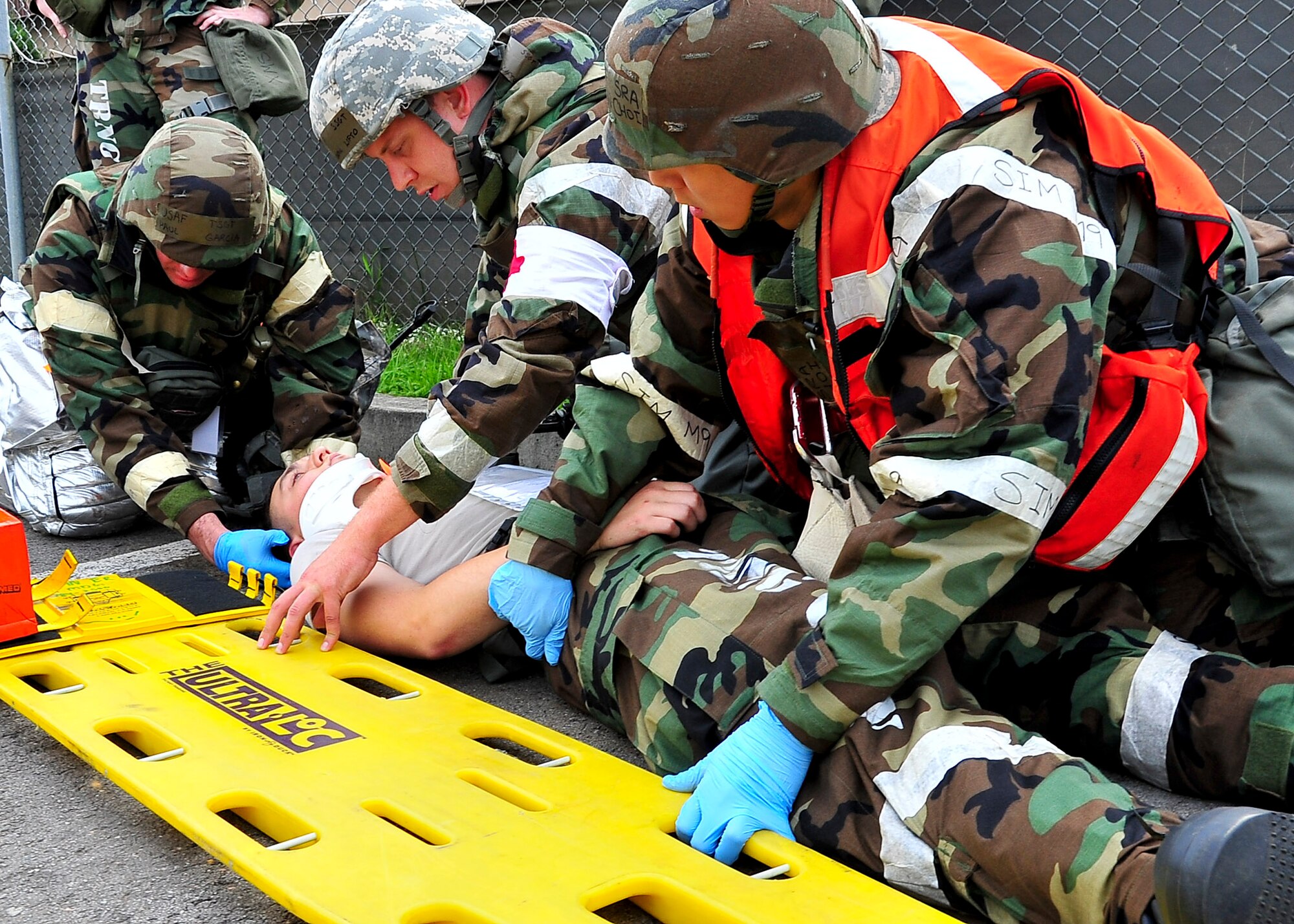 (Left) Tech. Sgt. Paul Garcia, 51st Civil Engineer Squadron fire fighter, Staff Sgt. Benjamin Lifto, 51st Medical Group independent duty medical technician and Senior Airman Kevin Choi, 51st Medical Group emergency responder, prepare to transport an injured Airman Aug. 30, 2011, during exercise Beverly-Midnight 11-04. Exercises, such as this, sharpen Osan's ability to survive and operate during combat. (U.S. Air Force photo/Senior Airman Adam Grant) 