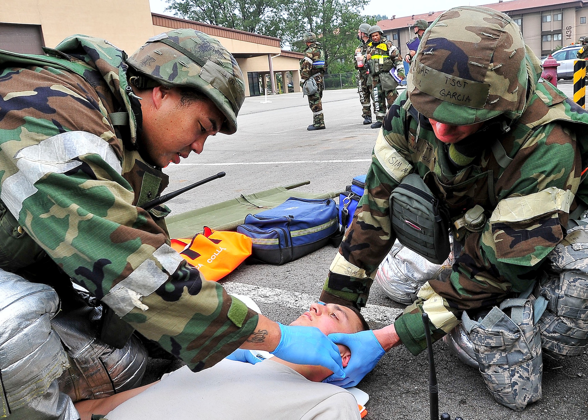 (Left) Senior Airman Larry Boyd and Tech. Sgt. Paul Garcia, both 51st Civil Engineer Squadron firefighters, stabilize the neck of a patient during a mass causality collection Aug. 30, 2011, during exercise Beverly-Midnight 11-04. Exercises, such as this, sharpen Osan's ability to survive and operate during combat. (U.S. Air Force photo/Senior Airman Adam Grant)  