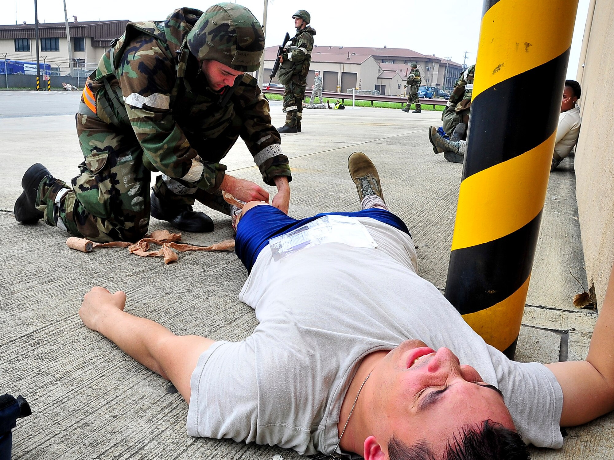 A member of the casualty collection team bandages a casualty’s double compound fracture Aug. 30, 2011, during exercise Beverly-Midnight 11-04. Exercises, such as this, sharpen Osan's ability to survive and operate during combat. (U.S. Air Force photo/Senior Airman Adam Grant)  