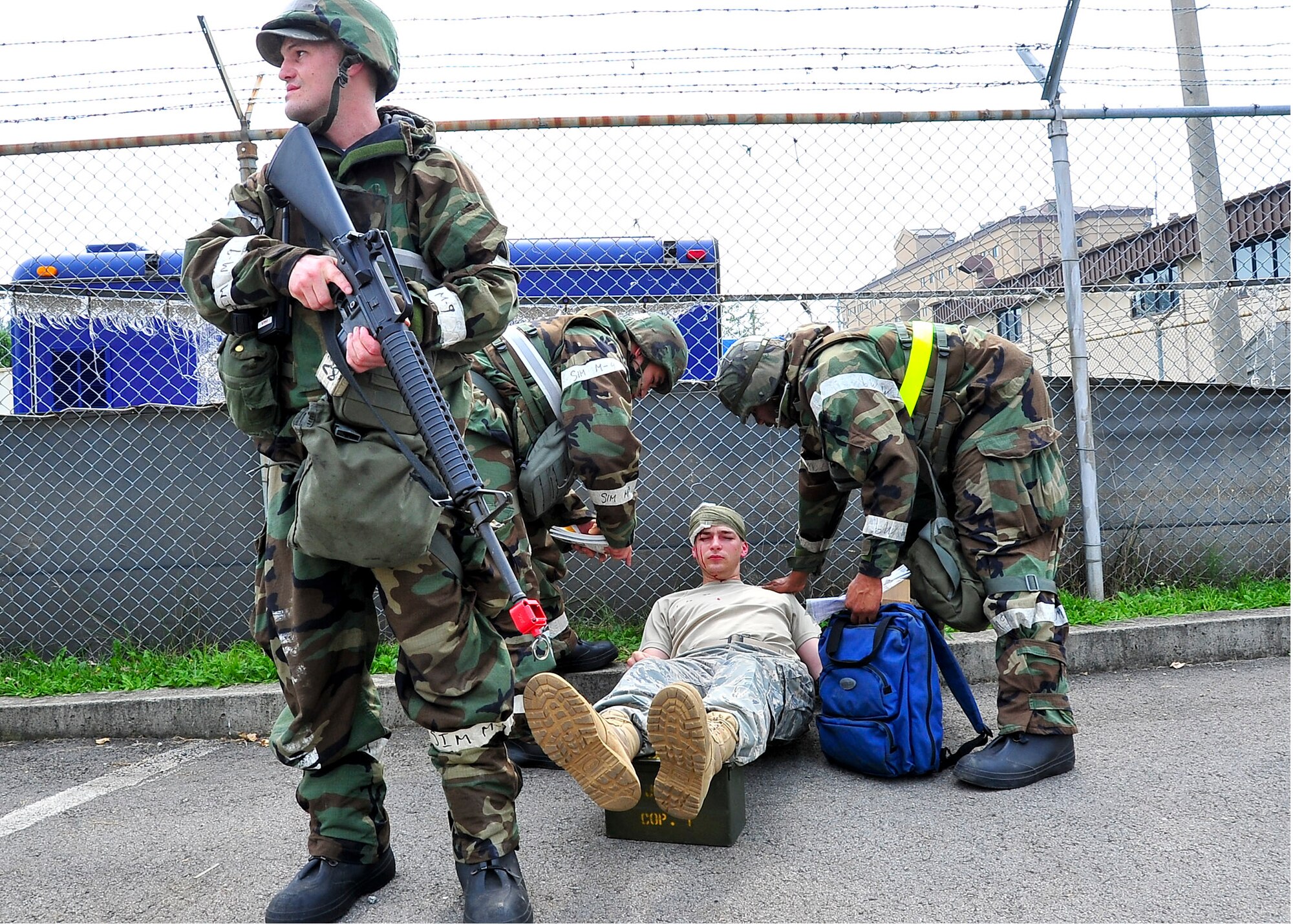 Senior Airman Raymond Zimmer, 51st Logistics Readiness Squadron vehicle operator, provides security while Airmen of the 51st Medical Group casualty collection team assess a patient’s injuries Aug. 30, 2011, during exercise Beverly-Midnight 11-04. Exercises, such as this, sharpen Osan's ability to survive and operate during combat. (U.S. Air Force photo/Senior Airman Adam Grant)  