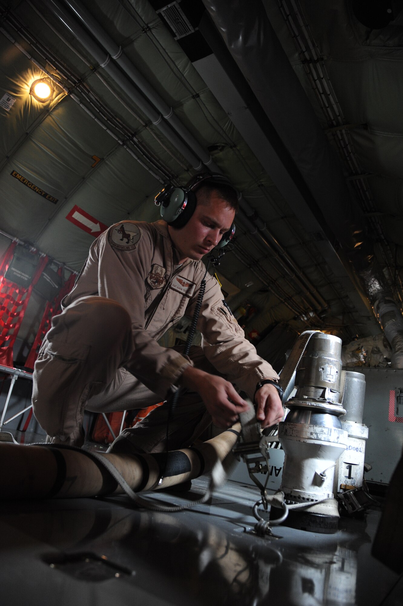 Staff Sgt. Aaron Tessmann, 22nd Expeditionary Air Refueling Squadron boom operator, ties down a spare fuel nozzle for the boom of a KC-135 Stratotanker deployed to the Transit Center at Manas, Kyrgyzstan, Aug. 27. Tessman is deployed from the 93rd Air Refueling Squadron at Fairchild Air Force Base, Wash. (U.S. Air Force photo/Tech. Sgt. Hank Hoegen)