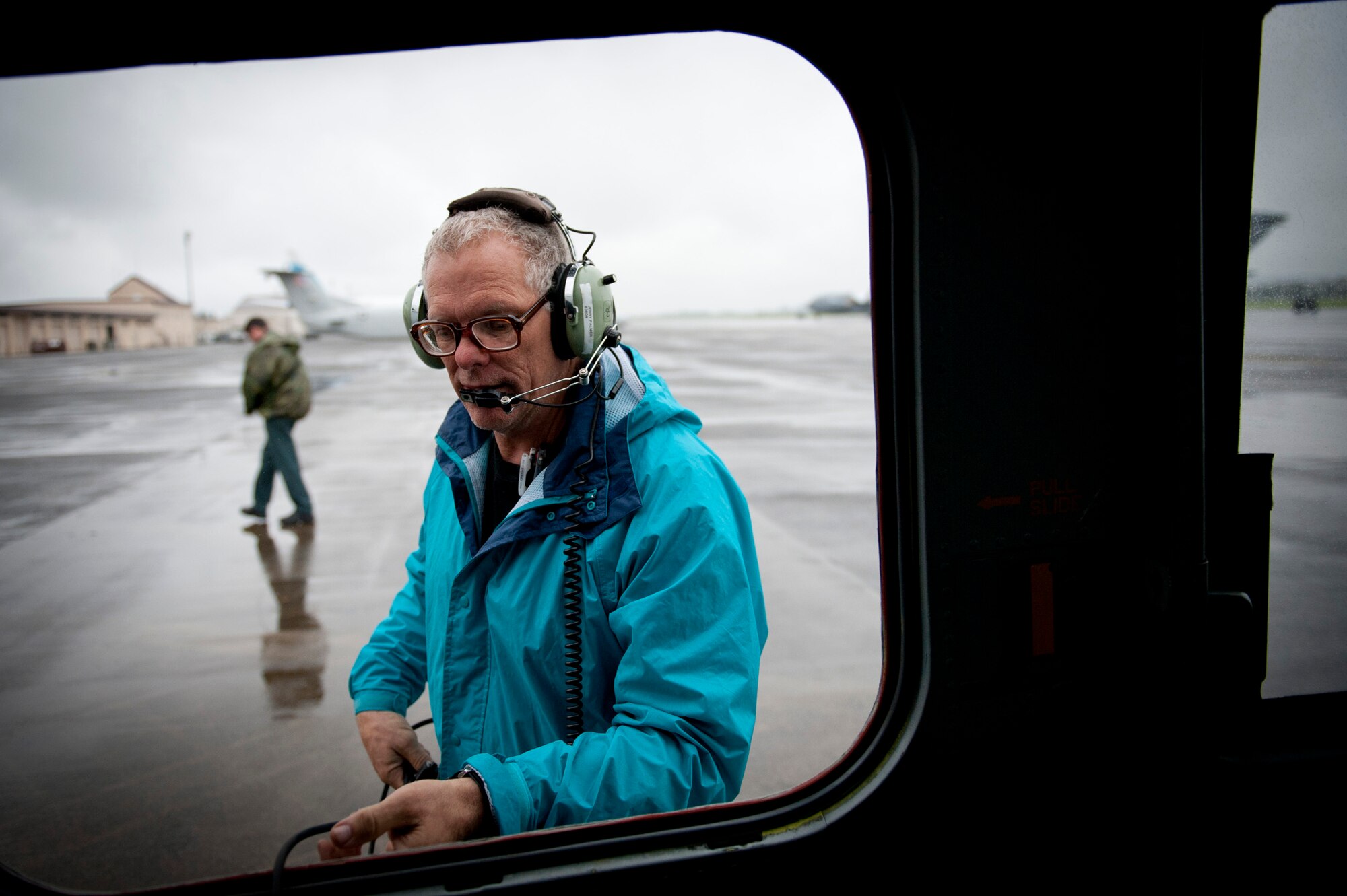 YOKOTA AIR BASE, Japan -- Jerry Palmer, 374th Maintenance Operations Squadron contractor, threads a communications cable out the window of a UH-1N Iroquois Aug. 21, 2011, at Yokota Air Base, Japan. The cable allowed Palmer to maintain communication with the pilot and co-pilot during engine startup to monitor progress from outside the helicopter. (U.S. Air Force photo/Staff Sgt. Samuel Morse)