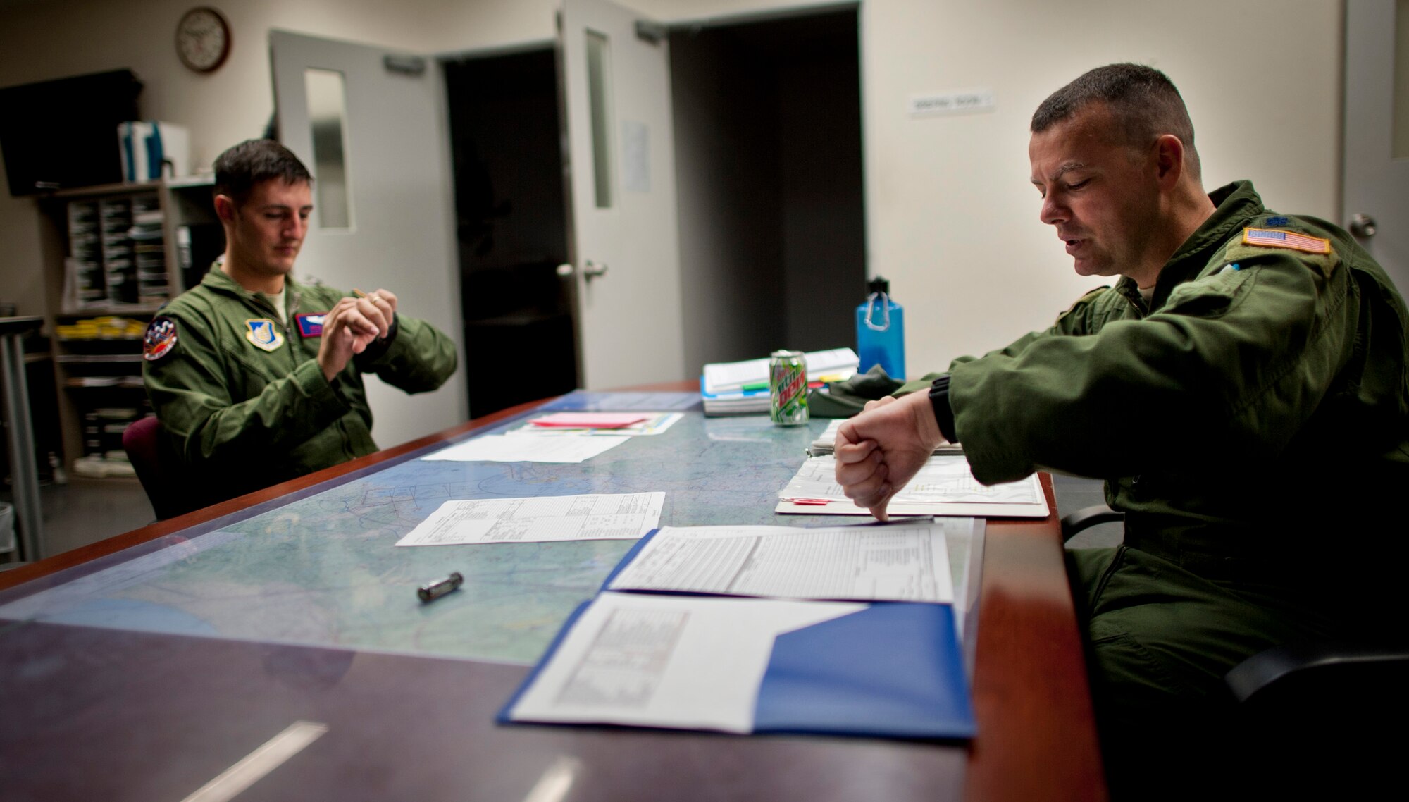 YOKOTA AIR BASE, Japan -- Lt. Col. Joshua Bowman (right), 459th Airlift Squadron director of operations, and Capt. Nicholas Ringo, 459th AS co-pilot, synchronize their watches during a pre-flight meeting Aug. 21, 2011, at the Japanese-American Friendship Festival, Yokota Air Base, Japan. (U.S. Air Force photo/Staff Sgt. Samuel Morse)
