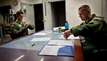 YOKOTA AIR BASE, Japan -- Lt. Col. Joshua Bowman (right), 459th Airlift Squadron director of operations, and Capt. Nicholas Ringo, 459th AS co-pilot, synchronize their watches during a pre-flight meeting Aug. 21, 2011, at the Japanese-American Friendship Festival, Yokota Air Base, Japan. (U.S. Air Force photo/Staff Sgt. Samuel Morse)