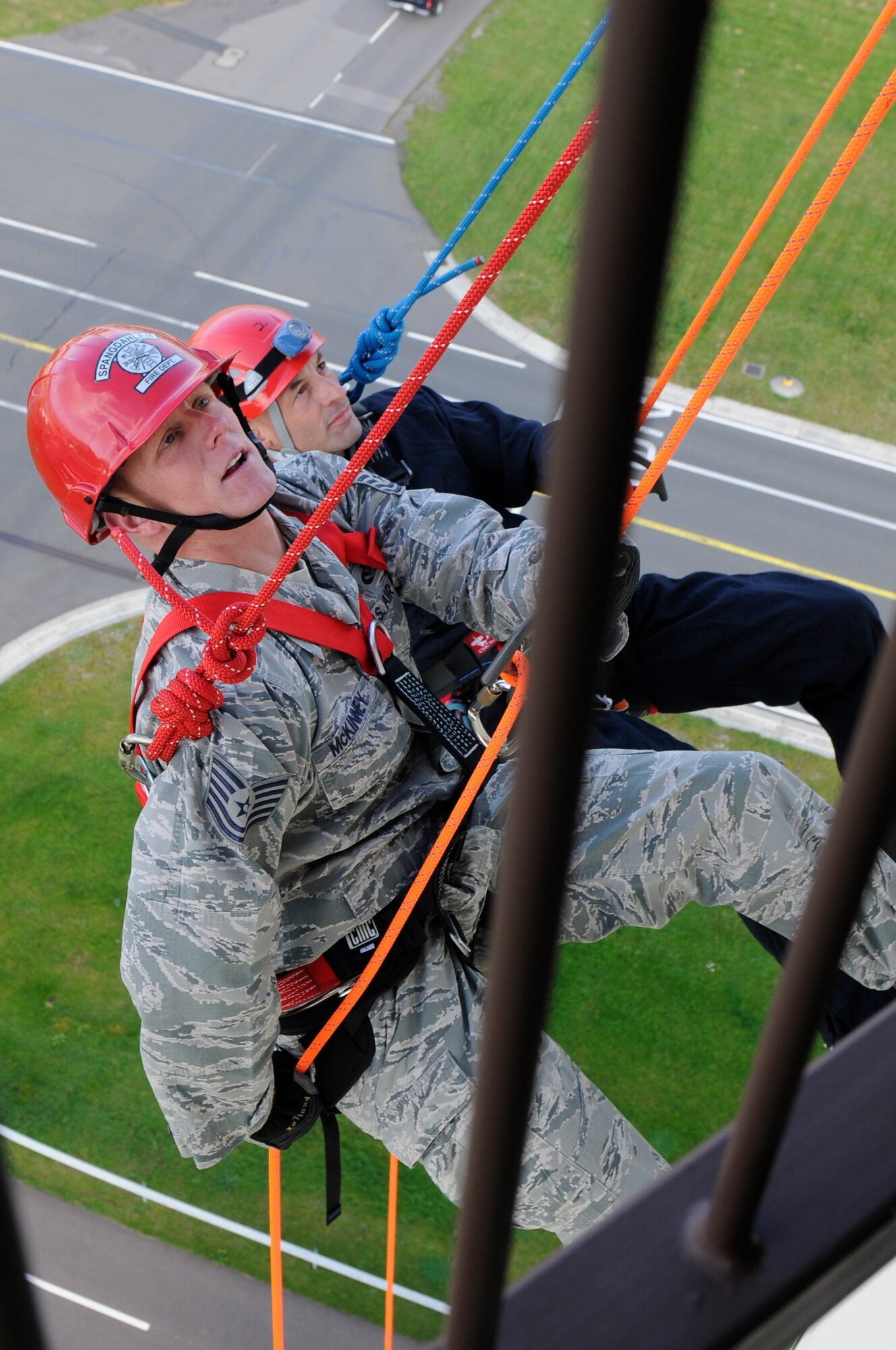 SPANGDAHLEM AIR BASE, Germany -- Tech Sgt. Zachary McKinney, 52nd Civil Engineer Squadron fire station captain, left, and Gerd Mueller, 52nd CES crew chief, rappel from the control tower during a training exercise here Aug. 29. The 52nd CES fire fighters train to rappel so they can be proficient in high-angle rescue techniques. (U.S. Air Force photo/ Airman 1st Class Brittney Frees)