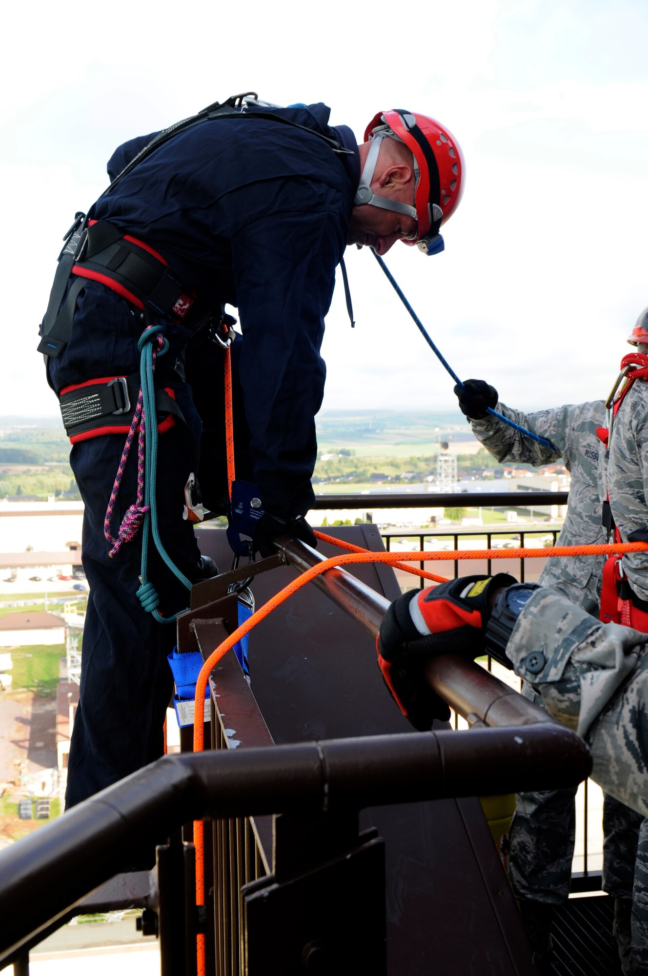 SPANGDAHLEM AIR BASE, Germany -- Gerd Mueller, 52nd Civil Engineer Squadron Fire Department crew chief, steps over the railing before rappelling from the control tower here Aug. 29. Fire fighters with 52nd CES train to rappel so they can be proficient in high-angle rescue techniques. (U.S. Air Force photo/ Airman 1st Class Brittney Frees)
