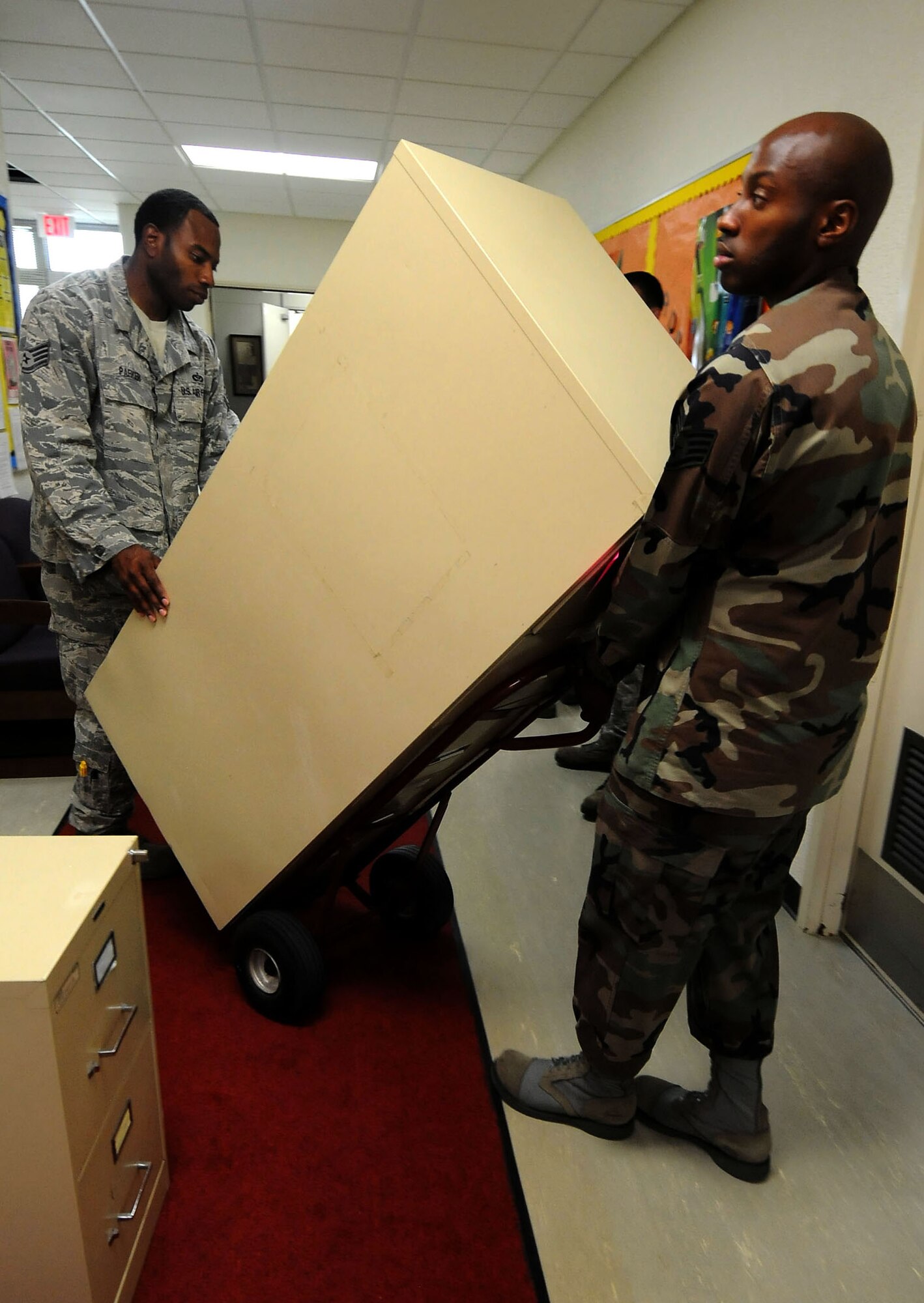 Staff Sgt. Jonnathan Clay, from the 353 Special Operations Group, carries a cabinet from one classroom to another at the Bob Hope Elementary School at Kadena Air Base, Japan, Aug. 26, 2011. More than 100 Airmen from all over Kadena volunteered to help move furniture and supplies at the school after Typhoon Mufia damaged some of the storage areas and classrooms. (U.S. Air Force photo by/Senior Airman Sara Csurilla)