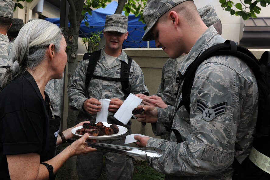 KUNSAN AIR BASE, Republic of Korea -- A volunteer from Steak Team Mission gives out appetizers to Airmen waiting to receive their steak dinner here Aug. 25. Steak Team Mission is a non-profit Dallas-based group that provides food and supplies for military men and women as a gesture of appreciation for their service. (U.S. Air Force photo/Senior Airman Brittany Y. Bateman)
