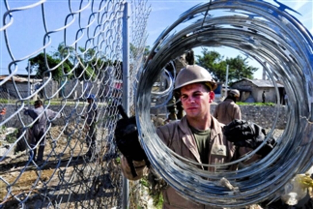 U.S. Marine Corps Lance Cpl. Steven Cole unravels razor wire at the Esaie Jeanty Hospital Cite Soleil engineering site during Continuing Promise 2011 in Port-au-Prince, Haiti, on Aug. 20, 2011.  Continuing Promise is a five-month humanitarian assistance mission to the Caribbean, Central and South America.  