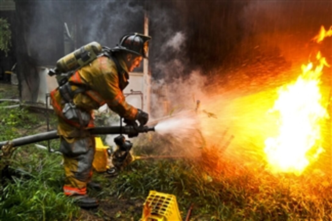 Army Pvt. 1st Class Lucas Ternell puts out a small debris fire in a yard in Salisbury, Md., on Aug. 27, 2011.  Ternell is a volunteer firefighter assigned to the 20th Military Police Company, Maryland National Guard.  Ternell was aboard Rescue 16, one of several fire and rescue engines that reported to the fire inside a residential neighborhood.  Guard members are providing support during the Hurricane Irene response.  