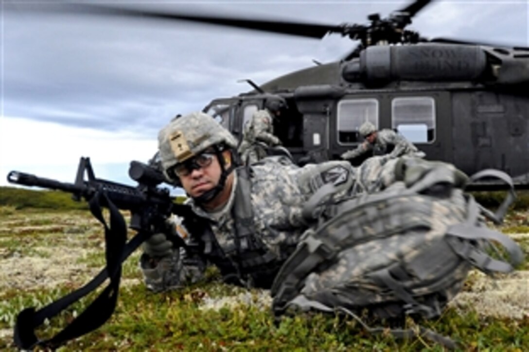 Army 1st Sgt. Gerald Eagan throws his rucksack in front of him while pulling security detail during a heliborne insertion mission as part of the Order of the Arctic Sapper competition on Joint Base Elmendorf-Richardson, Alaska, Aug. 17, 2011. Eagan is assigned to the 6th Engineer Battalion.