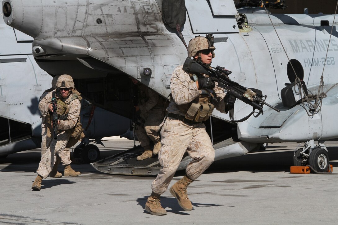 Team leader Cpl. Gerrick J. Watkins, right, and fellow squad members rehearse exiting a CH-46E Sea Knight parked on an air-station apron here Aug. 30 during a four-day course in which Company L riflemen learned to recover downed or lost pilots and personnel. Company L is one of three rifle companies in Battalion Landing Team 3/1, the ground-combat element of the 11th Marine Expeditionary Unit. Pilots from the unit’s aviation combat element, Marine Medium Helicopter Squadron 268 (Reinforced), flew helicopters in support of the course. Watkins is a 21-year-old Dallas native.