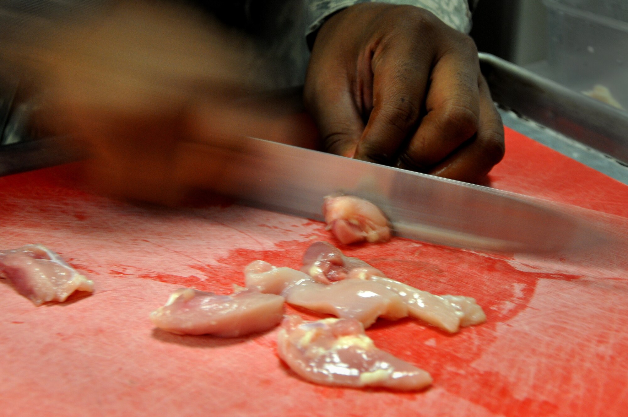 An Iron Chef contestant cuts chicken for his main dish at the Dining Facility, Shaw Air Force Base, S.C., Aug. 31, 2011. Four teams competed for the title of Iron Chef. The teams were tasked with the challenge to produce one entrée and one appetizer using what was provided in the kitchen and the surprise ingredient of red cabbage. The products were judged on the categories of taste, presentation, creativity and incorporation of the special ingredient. (U.S. Air Force photo/Senior Airman Alexandria Mosness) (Released)