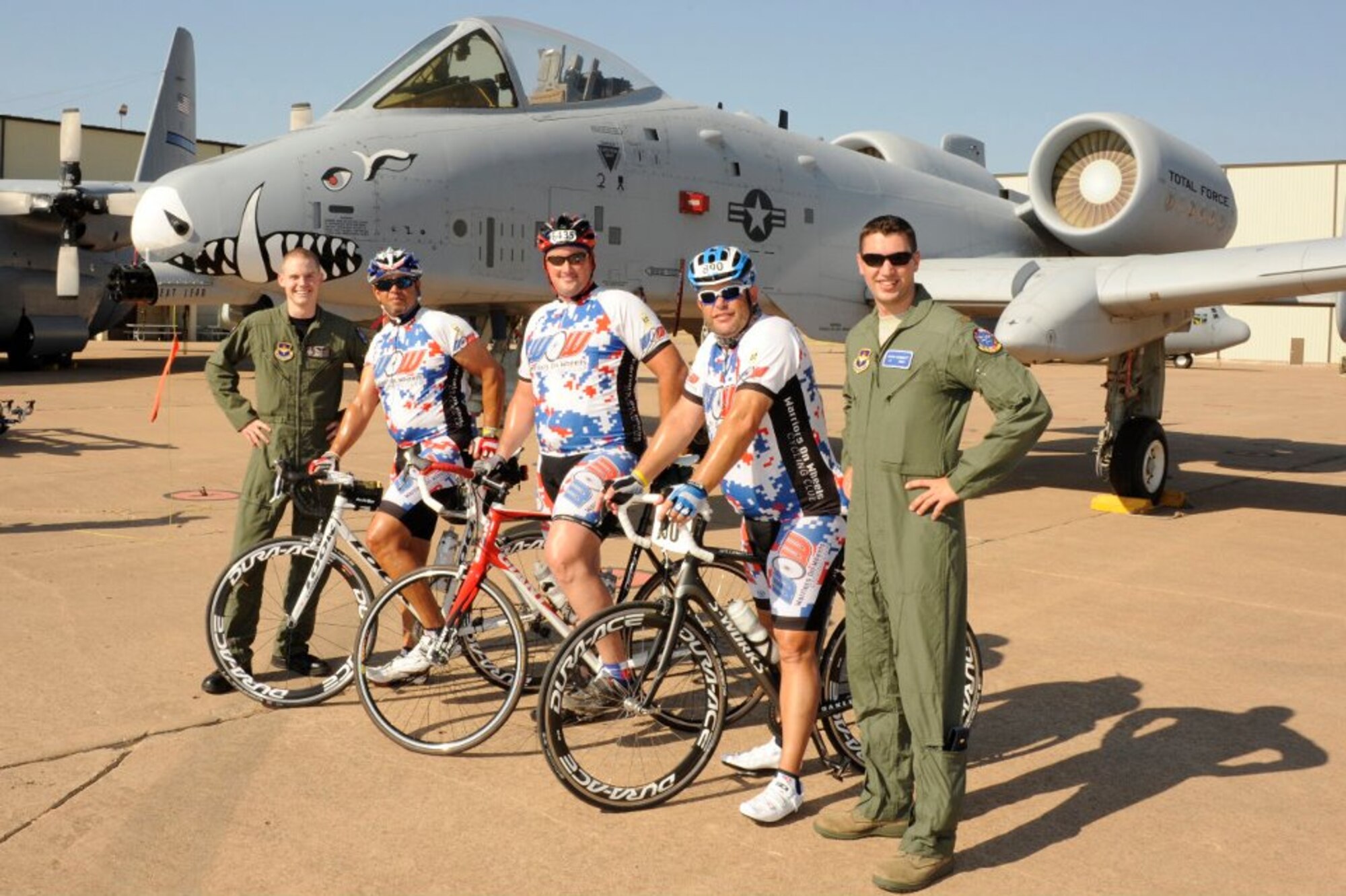 Riders from Hotter'N Hell Hundred pose for a photo with pilots from the 80th Flying Training Wing in front of an A-10 Warthog. This year the Euro-NATO Joint Jet Pilot Training Program celebrates 30 years of excellence in conjunction with Hotter'N Hell Hundred. (U.S. Air Force Photo/Danny Webb)