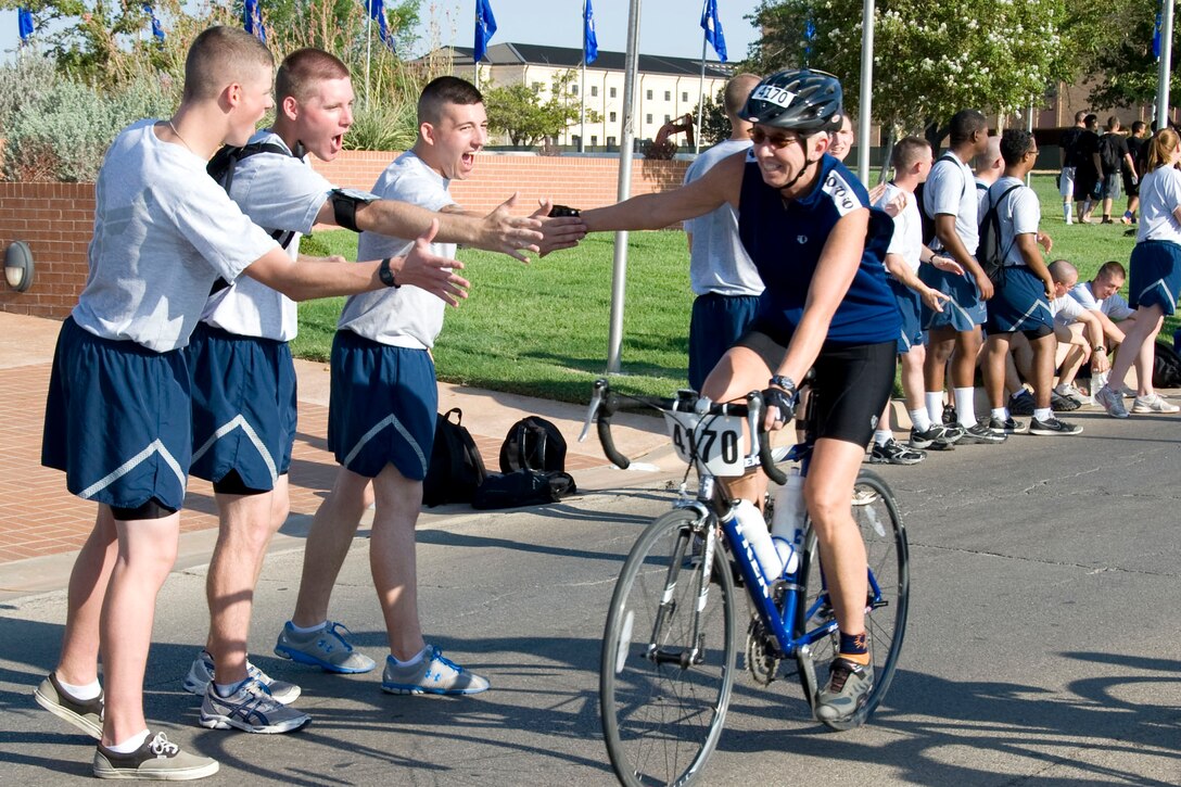 365th Training Squadron avionics students Airman 1st Class Matthew Kersey from Warsaw, Mo., Airman Basic Blaine Russell from St. Genevieve, Mo., and Airman First Class Colin Anderson from La Plata, Md., cheer on riders as they pass through Airmen's Alley, Sheppard Air Force Base, Aug. 27.
