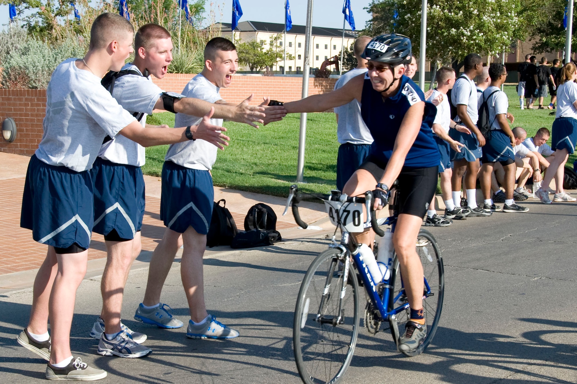 365th Training Squadron avionics students Airman 1st Class Matthew Kersey from Warsaw, Mo., Airman Basic Blaine Russell from St. Genevieve, Mo., and Airman First Class Colin Anderson from La Plata, Md., cheer on riders as they pass through Airmen's Alley, Sheppard Air Force Base, Aug. 27.