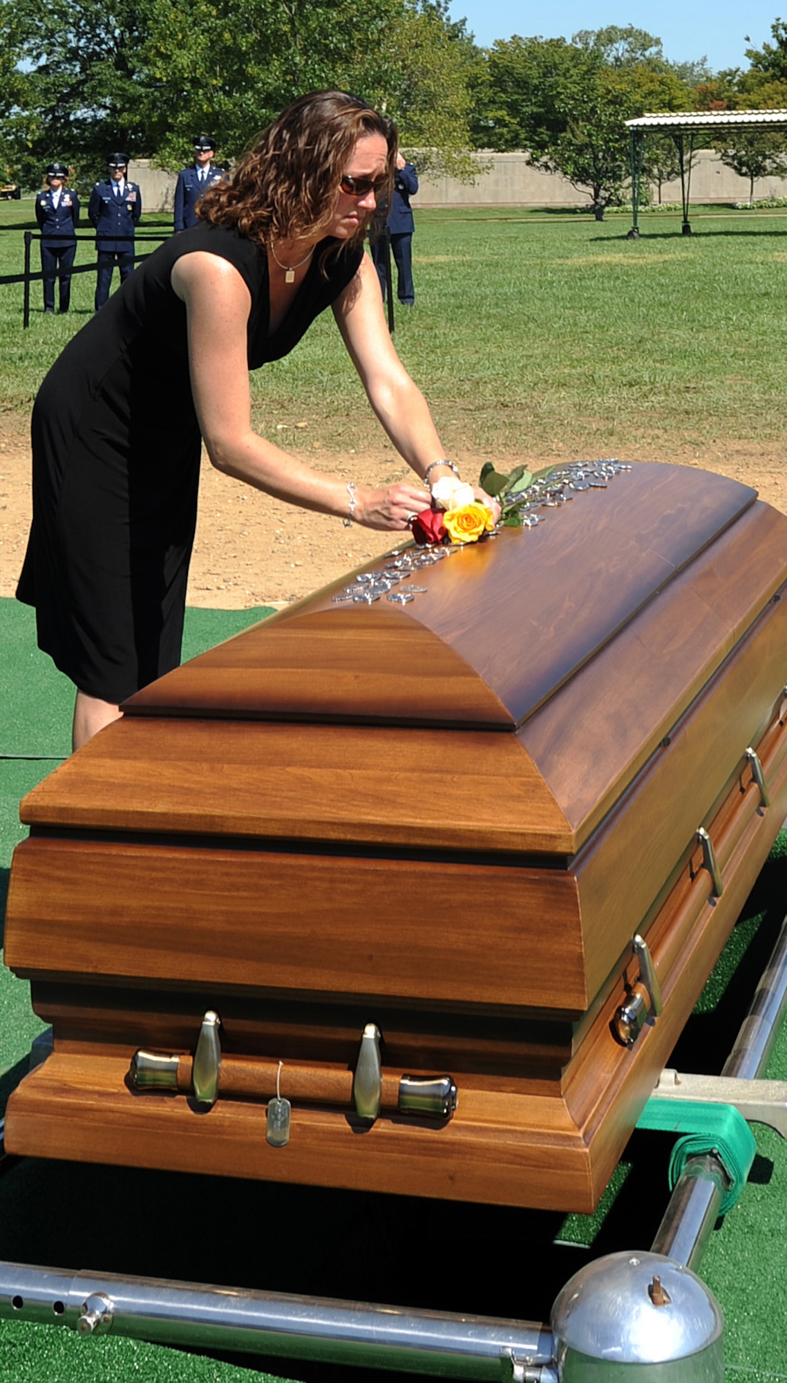 ARLINGTON, Va. -- Tabitha Brown places roses on top of her husband?s casket during a funeral ceremony at Arlington National Cemetery Aug. 30, 2011. Her husband, Tech. Sgt. John Brown was one of 30 Americans killed in the Aug. 6 crash of a CH-47 Chinook helicopter in eastern Afghanistan. (U.S. Air Force photo/Staff Sgt. Tiffany Trojca)