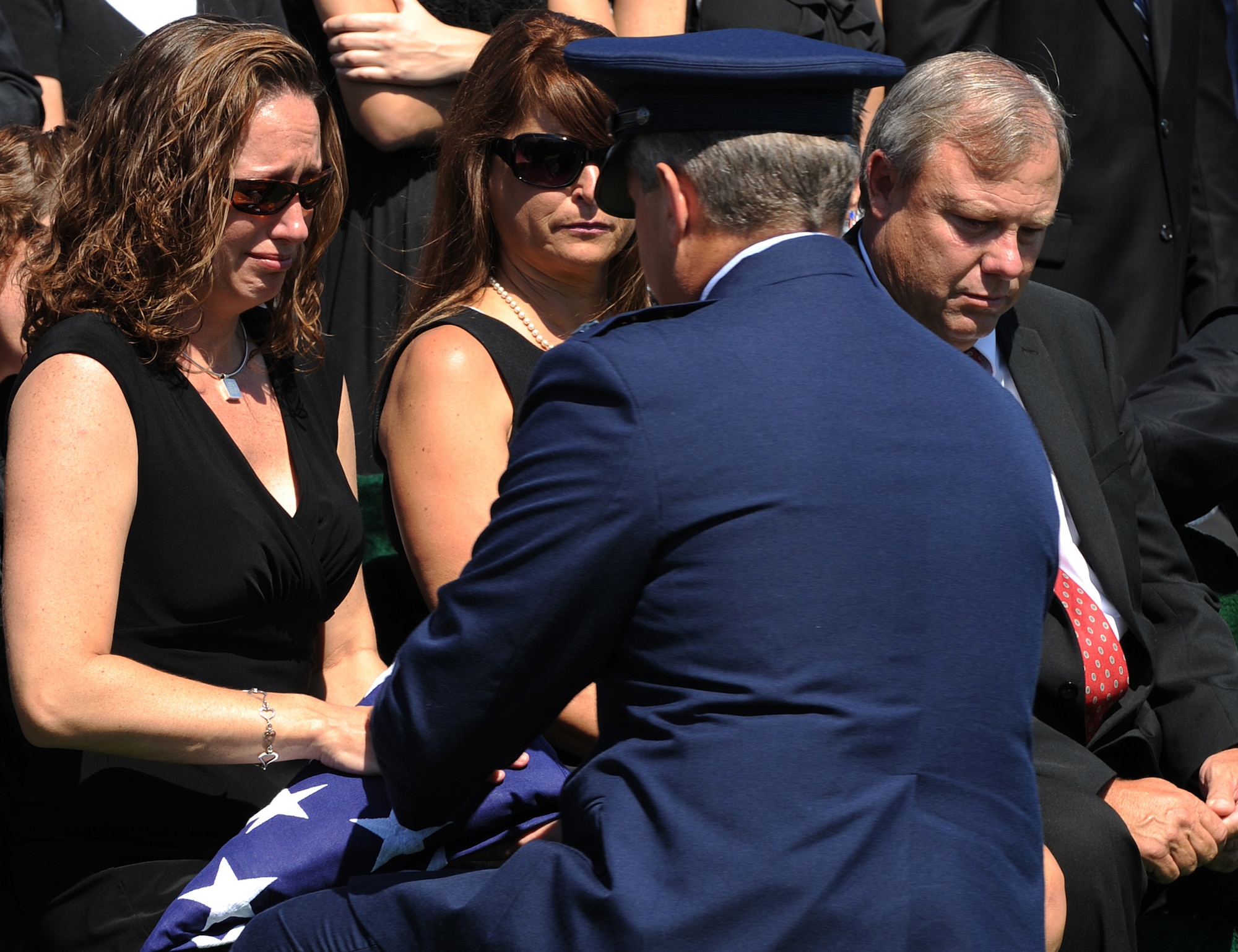 ARLINGTON, Va. -- Tabitha Brown accepts a flag from Air Force Special Operations Command Lt. Gen. Eric Fiel in honor of her husband, Technical Sgt. John Brown, during a funeral ceremony at Arlington National Cemetery Aug. 30, 2011. Brown was one of 30 Americans killed in the Aug. 6 crash of a CH-47 Chinook helicopter in eastern Afghanistan. (U.S. Air Force photo/Staff Sgt. Tiffany Trojca)