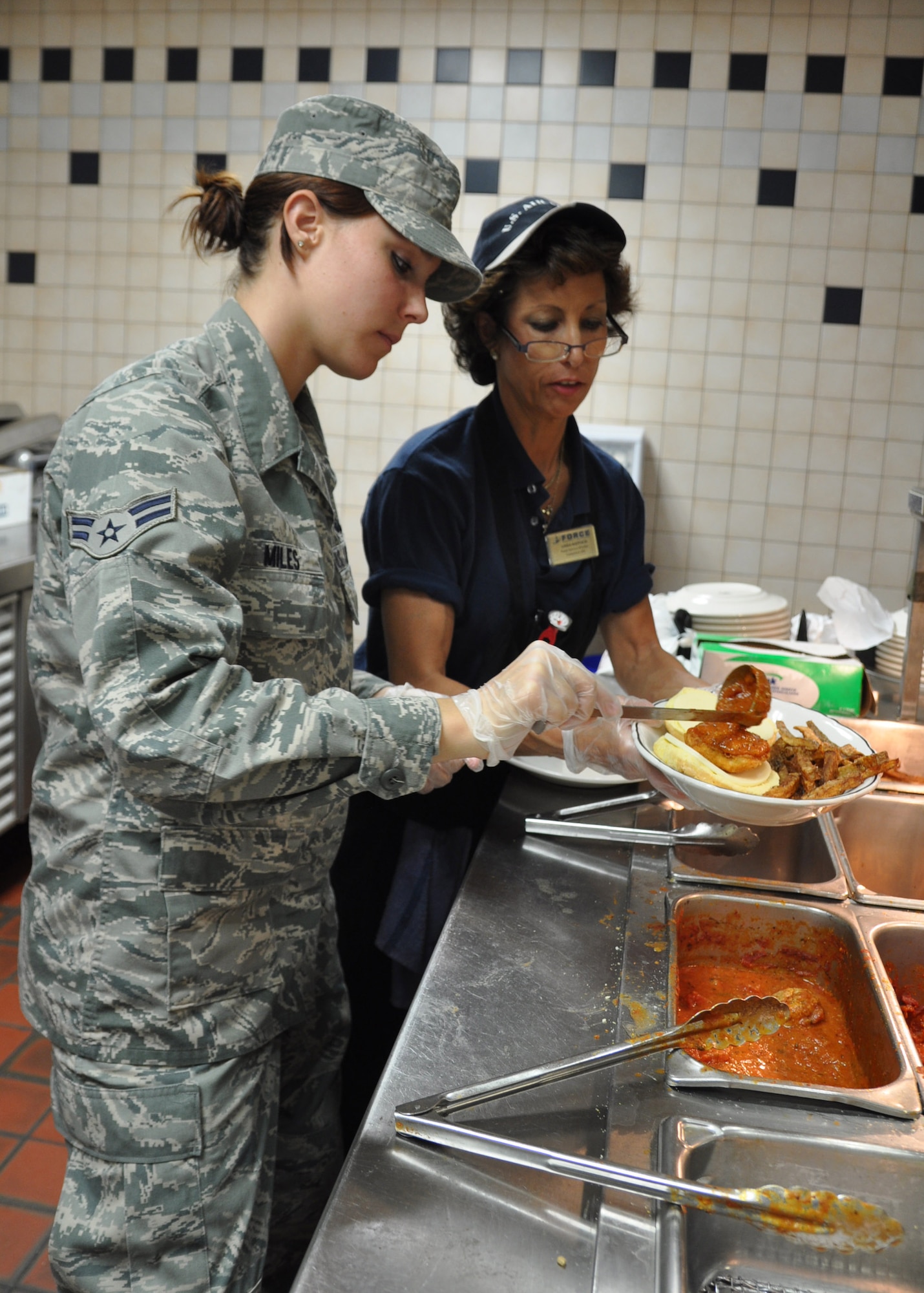 YOUNGSTOWN AIR RESERVE STATION,Ohio — Air Force Reserve Airman 1st Class Sarah E. Miles, a services journeyman with the 910th Force Support Squadron, prepares a lunch dish at the 910th Airlift Wing's Community Activity Center. Miles is a student at Youngstown State University pursuing a degree in Political Science. U.S. Air Force photo by Maj. Brent J. Davis