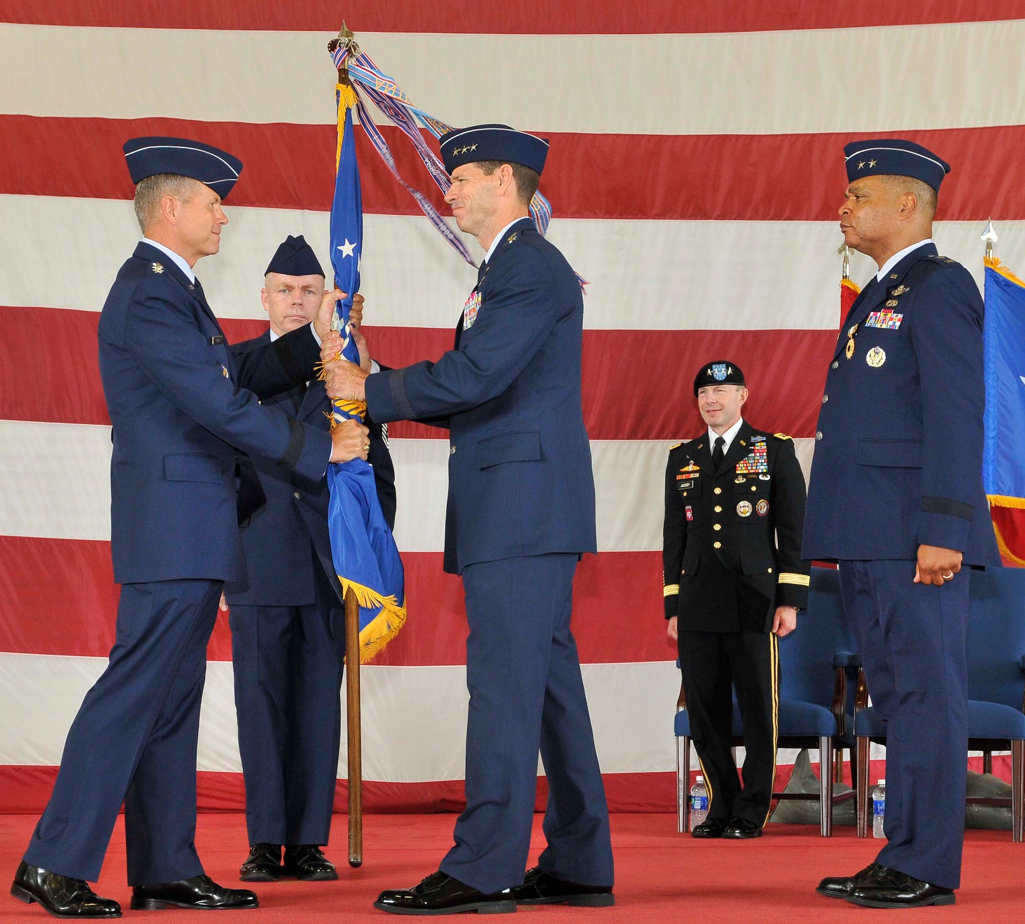 Gen. William M. Fraser, left, Air Combat Command commander, passes the 1st Air Force flag to Lt. Gen. Sid Clarke during the Continental U.S. North American Aerospace Defense Command Region-1st Air Force (Air Forces Northern) change of command ceremony at Tyndall Air Force Base, Fla., Aug. 31. Clarke assumed command of 1st Air Force from Maj. Gen. Garry C. Dean, marking the first time a lieutenant general has ever held a command billet at Tyndall. (U.S. Air Force photo by Lisa Norman)