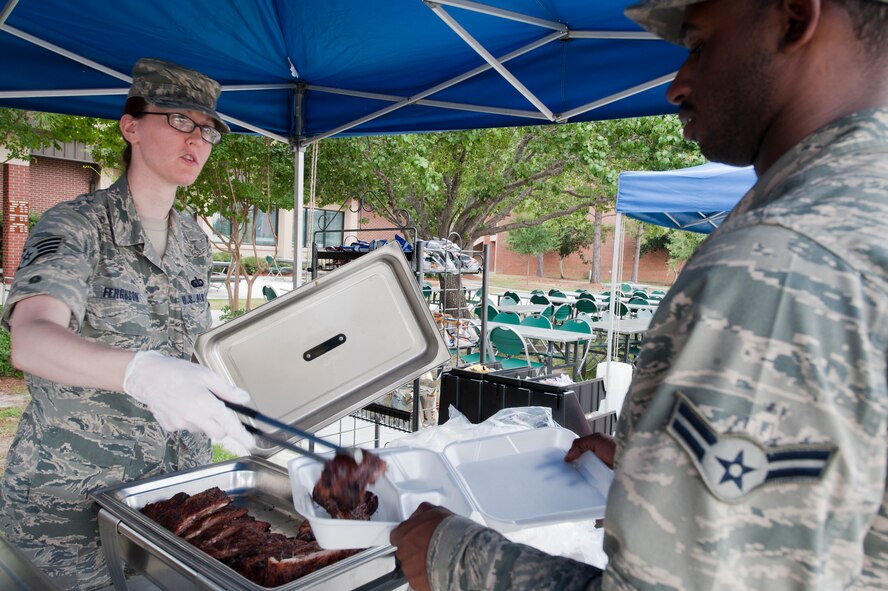 U.S. Air Force Staff Sgt. Holly Ferguson, a food services specialist with the 23rd Force Support Squadron (FSS), serves Airman 1st Class Antwan McGruder, 23rd Logistic Readiness Squadron, barbecued ribs during a 23rd FSS block party Aug. 30, 2011. The Georgia Pines Dining Facility is currently competing for the John L. Hennessy Award where if won, the facility will receive a trophy and money for facility upgrades.  (U.S. Air Force photo by Staff Sgt. Joshua J. Garcia/Released)