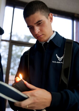 Airman 1st Class Jason Whipps burns strings off of his uniform at Joint Base Charleston - Air Base Aug. 26. Whipps was ensuring his uniform was perfect prior to performing at a retirement ceremony. (U.S. Air Force photo/Staff Sgt. Katie Gieratz)