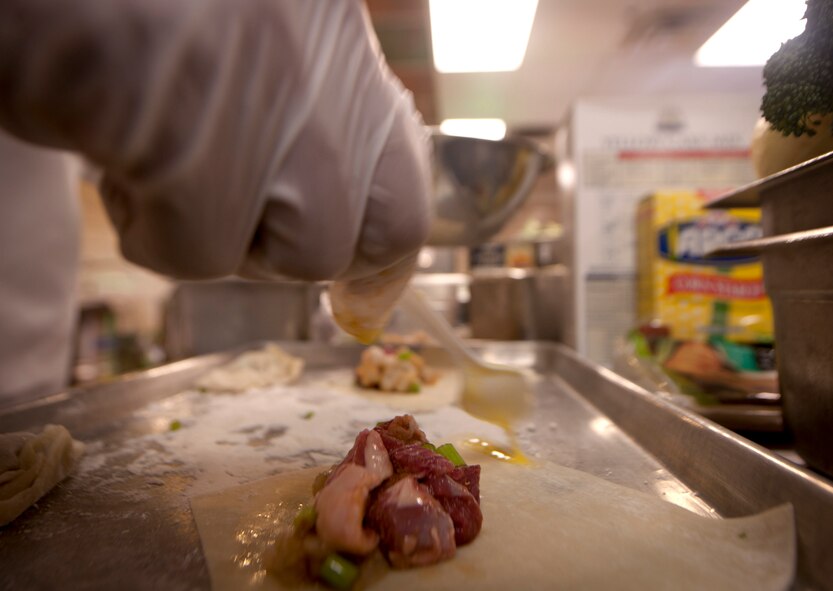Butter is spread on the outer edges of a lamb dumpling during the Iron Chef Competition at Moody Air Force Base, Ga., Aug. 30, 2011. The lamb, which was a secret ingredient, had to be used in at least two of the meals served to the judges. (U.S. Air Force photo by Airman 1st Class Joshua Green/Released)
