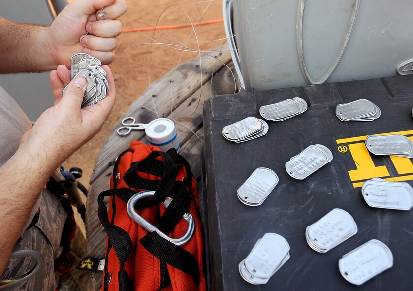 Staff Sgt. Granville Smith, 85th Engineering and Installation Squadron technician, Keesler Air Force Base, Miss., gathers dog tags to be used to label cables on the new Command Post tower on Barksdale Air Force Base, La., Aug. 31. With more than 4,500 feet of cable running from the top of the 149-foot tower to the building below, the Airmen use the dog tags to label the cables for numbering and locating them. (U.S. Air Force photo/Senior Airman Amber Ashcraft) (RELEASED)