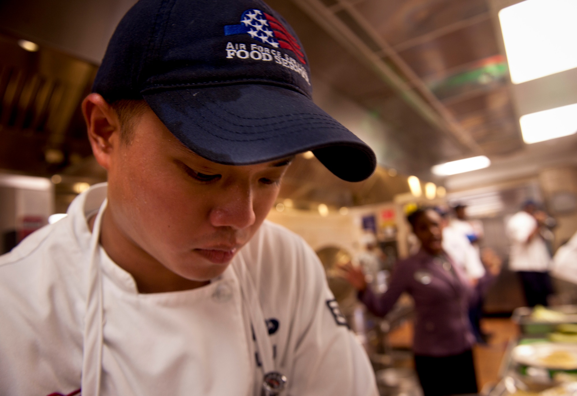 U.S. Air Force Senior Airman Jonny Liu, team Rush Hour member representing the 23rd Force Support Squadron, stays focused on the task at hand as the remaining time limit is yelled out during the Iron Chef Competition at Moody Air Force Base, Ga., Aug. 30, 2011. Competitors were given an hour to prepare, cook and have their meals ready for the judges to taste and judge. (U.S. Air Force photo by Airman 1st Class Joshua Green/Released)

