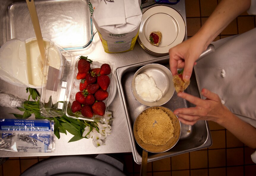 Sour cream and brown sugar is spread on a strawberry for a food dessert during the Iron Chef Competition at Moody Air Force Base, Ga., Aug. 30, 2011. This was the first ever Iron Chef Competition sponsored by the 23rd Force Support Squadron and was judged by the 23rd Wing leadership. (U.S. Air Force photo by Airman 1st Class Joshua Green/Released)
