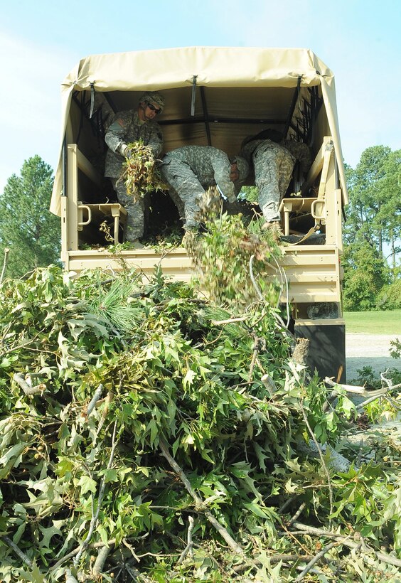 U.S. Army Pfc. Edwin Martinso, William Hobb, and Angel Medina 7th Sustainment Brigade inland cargo transfer specialist, dispose of debris caused by Hurricane Irene at Fort Eustis, Va., Aug. 29, 2011. Hurricane detail teams were implemented across the installation to assist and expedite recovery. (U.S. Air Force photo by Staff Sgt. Antoinette Gibson/Released)