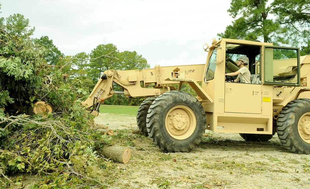 U.S. Army Spc. Andrea Lagrow, 567th Transportation Company 10K operator, organizes debris at the drop off point at Fort Eustis, Va., Aug. 29, 2011. According to officials the storm knocked out power to more than 4 million people and was responsible for at least 20 deaths along the East Coast. (U.S. Air Force photo by Staff Sgt. Antoinette Gibson/Released)