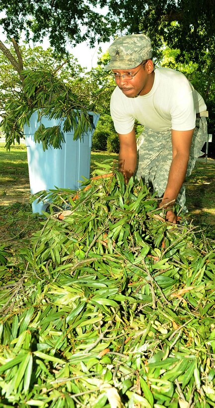 U.S. Army Sgt. Micheal Holden, U.S. Army Element Regimental Chapel assistant, clean up a fallen tree branch caused  by Hurricane Irene at Fort Eustis, Va., Aug. 29, 2011. Winds reached speeds of 60 mile per hour at Ft. Eustis causing trees to fall across base.(U.S. Air Force photo by Staff Sgt. Antoinette Gibson/Released)