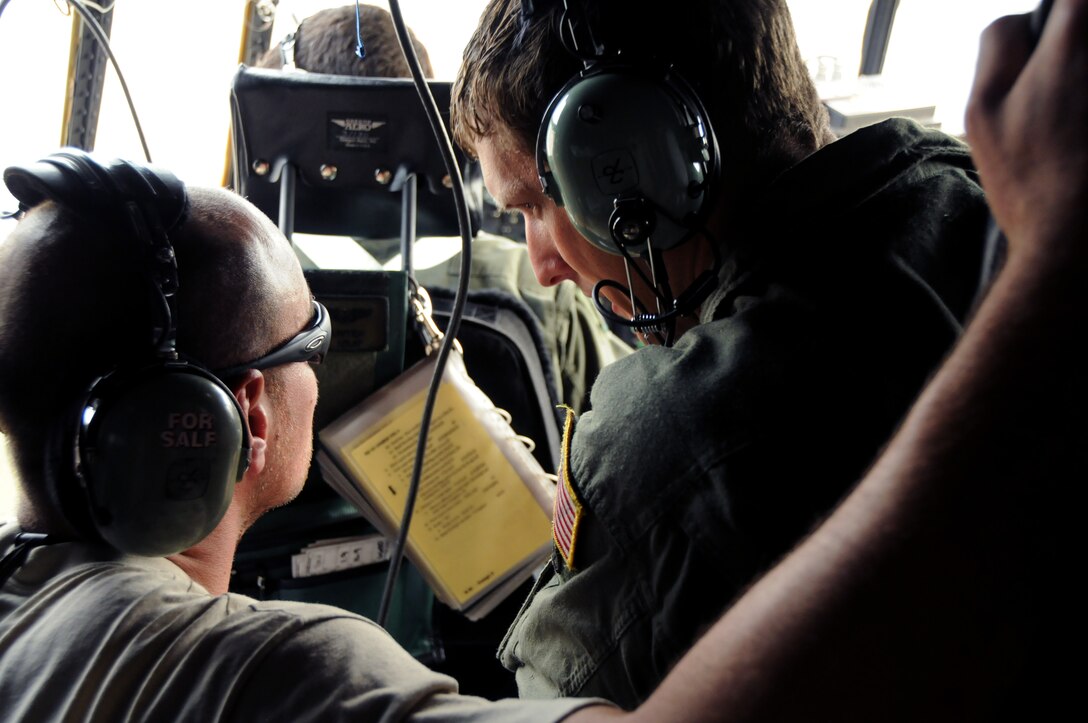 Staff Sgt. Cris Hunter, a flight engineer for 711th Special Operations Squadron, confers with a crew chief about a maintenance issue with a MC-130E Talon I on Duke Field, Fla. The flight engineer monitors the aircraft systems and calculates performance capabilities of the aircraft. The 711th SOS, part of the 919th Special Operations Wing, conducts flight training missions five days a week to maintain currency on all of their readiness requirements. (U.S. Air Force photo/Tech. Sgt. Cheryl Foster)