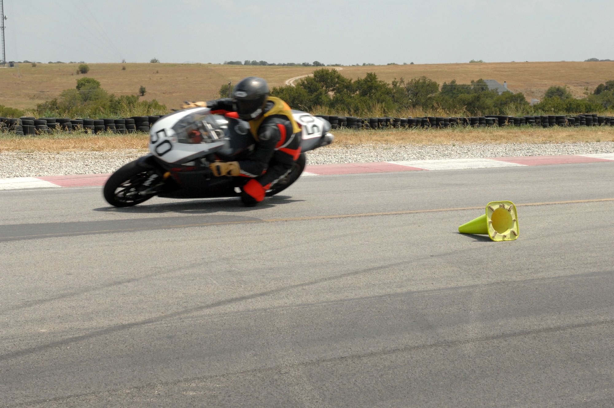 Capt. Van Blaylock, 317th Airlift Group and racetrack instructor, demonstrates the proper lean angle and body position in a curve during the proposed Advance Motorcycle Training Program, the first of its kind in the Air Force, at Eagles Canon Raceway, Decatur, Texas, on Aug. 22, 2011. (U.S. Air Force photo by 2nd Lt. AnnMarie Annicelli/Released)