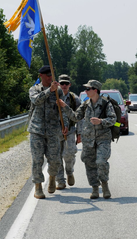 U.S. Air Force Chief Master Sgt. Bryan Vibert, 633rd Security Forces Squadron security forces manager, passes the guidon to Master Sgt. Stacy Reeves, Air Combat Command Headquarters SFS training manager, during the Security Forces 9/11 Ruck March to Remember in Amherst, Va., Aug 25, 2011. Security Forces units participated in the march in remembrance of the terrorist attacks on Sept. 11, 2001 and the defenders who have lost their lives in support of Operation Enduring Freedom. (U.S. Air Force photo by Airman 1st Class Racheal Watson/Released)