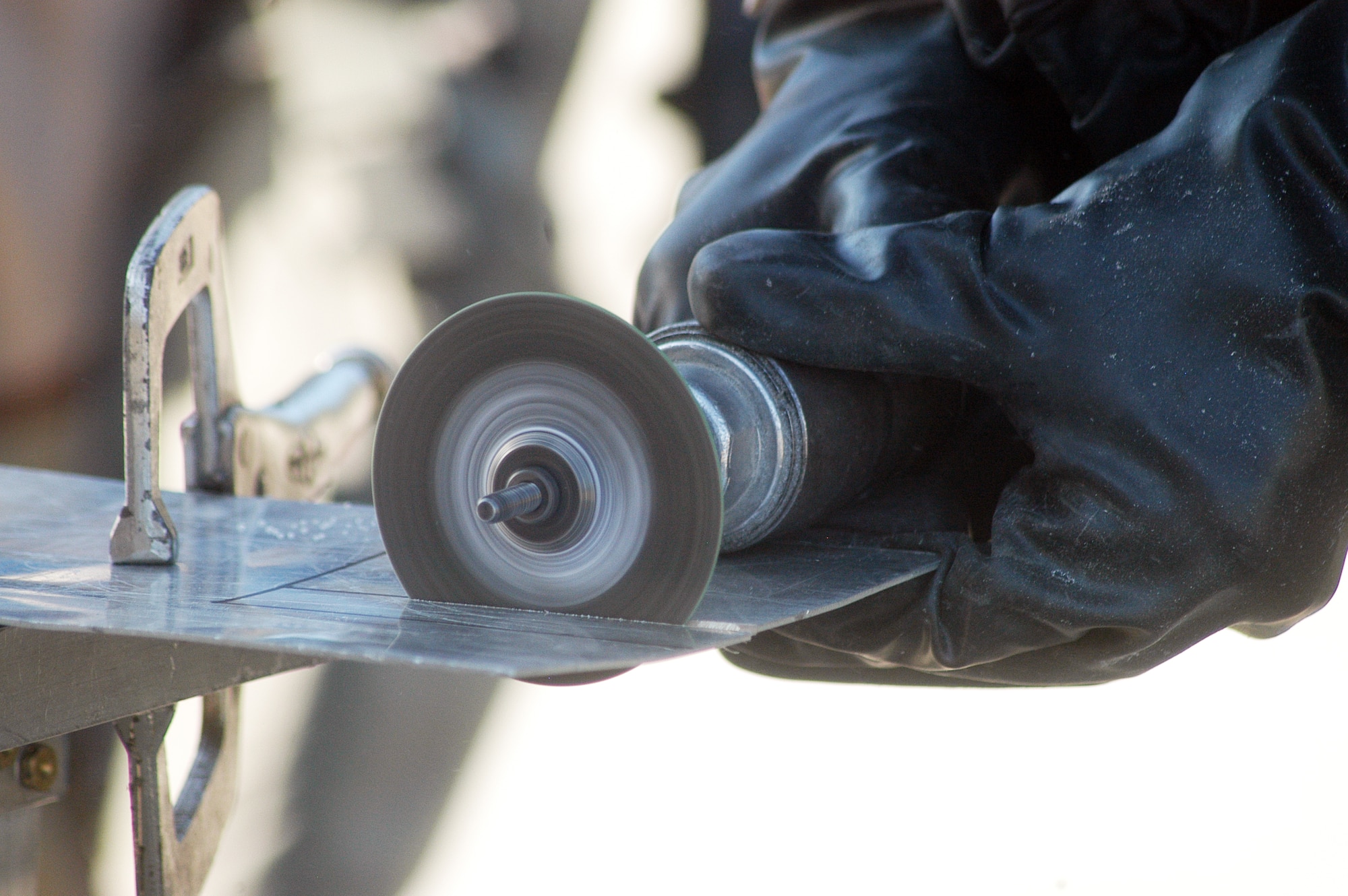 Team members participating in the 402nd EDMX exercise cut a piece of sheet metal to repair battle damage to an aircraft after a simulated attack on their base. U. S. Air Force photo by Sue Sapp