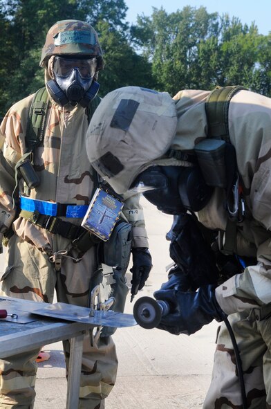 Team members participating in the 402nd EDMX exercise cut a piece of sheet metal to repair battle damage to an aircraft after a simulated attack on their base. U. S. Air Force photo by Sue Sapp