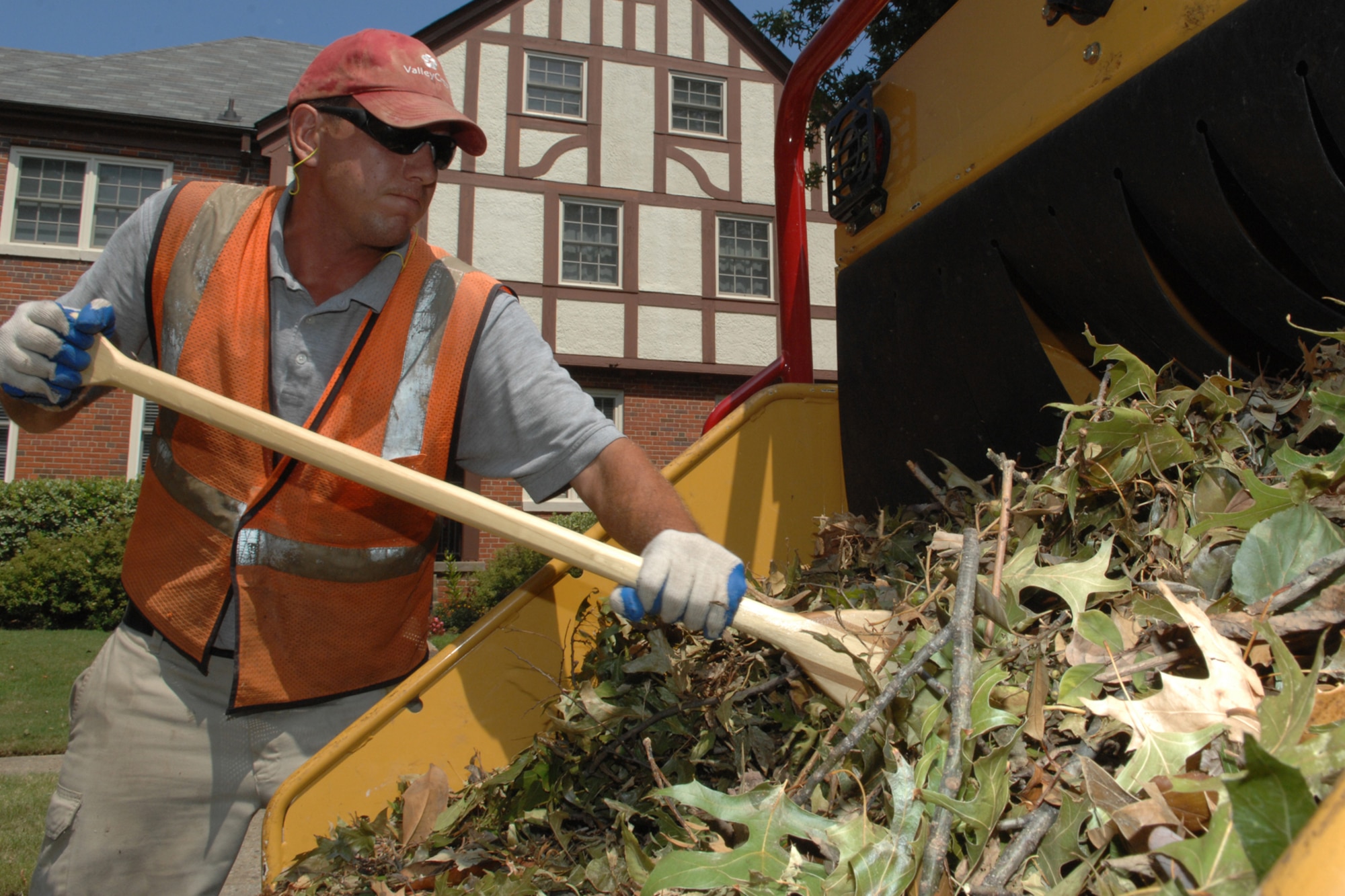 Matt Lamberski, a contractor from a local landscaping company, puts leaves and branches into a wood chipper Aug. 30, 2011 at Langley Air Force Base, Va. The landscapers have been on base since Sunday to clean up debris left in the wake of Hurricane Irene. (United States Air Force photo by Staff Sgt. Jeff Nevison/RELEASED)