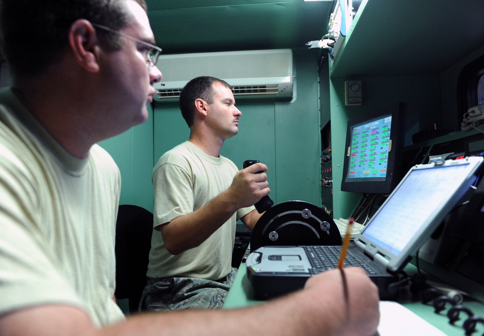 U.S. Air Force Staff Sgt. Todd Goucher, 20th Component Maintenance Squadron test cell technician, records temperatures and observes the engine while U.S. Air Force Tech. Sgt. Michael Sierra, 20th CMS test cell assistant section chief, prepares a test cab for an engine run by setting switches and monitoring the engine parameters at Shaw Air Force Base, S.C. Aug. 30, 2011. The F110-General Electric-129 F-16 Fighting Falcon engine is tested at the hush house. The hush house is a term used for an enclosed, noise suppressed test facility for installed or uninstalled engines under a variety of engine operating conditions. (U.S. Air Force photo/Airman 1st Class Tabatha L. Duarte)(Released)