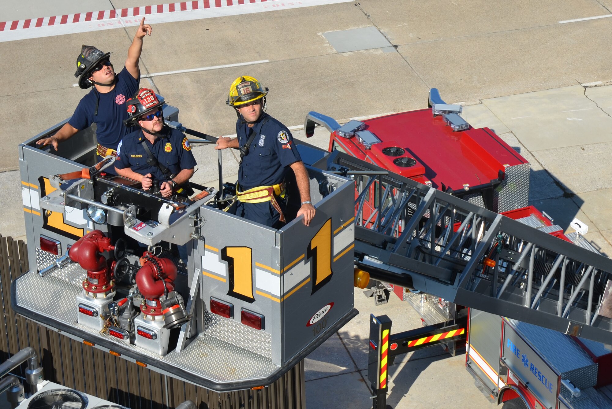 Firefighters maneuver the aerial ladder to the cab of the newly opened air traffic control tower during mutual aid training here Aug. 23-24. (U.S. Air Force Photo/Don Peek)