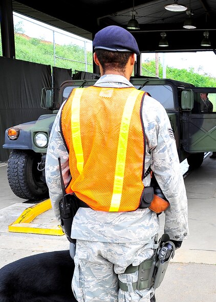 Staff Sgt. Damien Mills, 51st Security Forces Squadron military working dog handler, waits as the driver of a Humvee opens all doors before his military working dog “Milo” begins searching Aug. 29, 2011 during exercise Beverly-Midnight 11-04. During the search “Milo” is looking for contraband and prohibited items that are not allowed on Osan Air Base. (U.S. Air Force photo/Senior Airman Adam Grant)