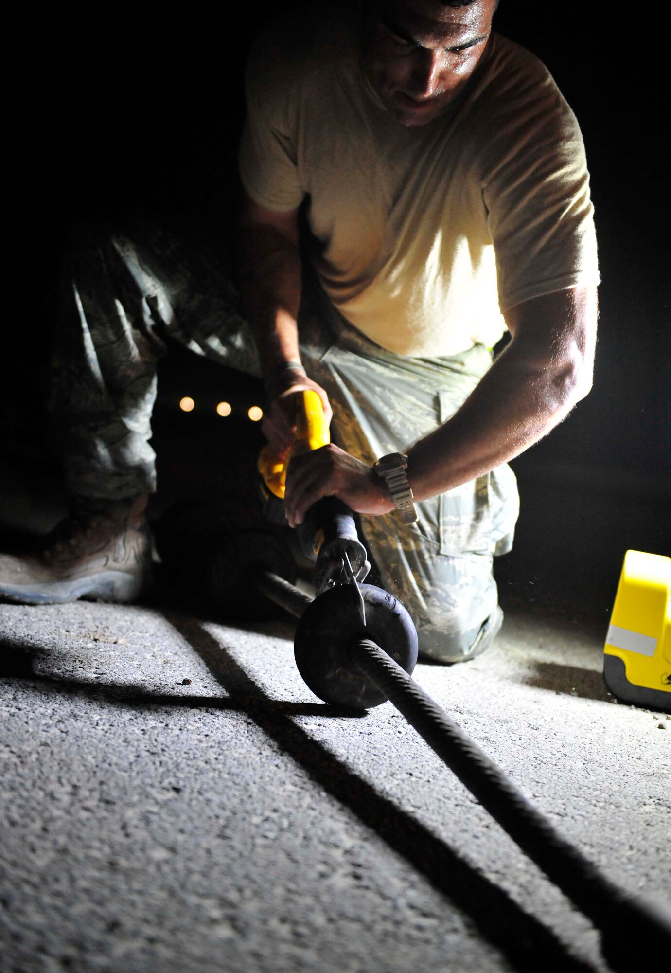 Senior Airman Jason Senter, from the 380th Expeditionary Civil Engineer Squadron, cuts off unserviceable cable spacers on the mobile aircraft arresting system Aug. 27, 2011, during a two-week maintenance overhaul of the system at an air base in Southwest Asia. This maintenance is due every 10 years. The MAAS is an emergency braking system for tail-hook-equipped aircraft. It is used in emergency situations where a fighter aircraft needs assistance with coming to a stop after flight. This occasionally occurs due to mechanical failures beyond the pilot's abilities to correct prior to landing.  (U.S. Air Force photo/Tech. Sgt. Patrick Mitchell)