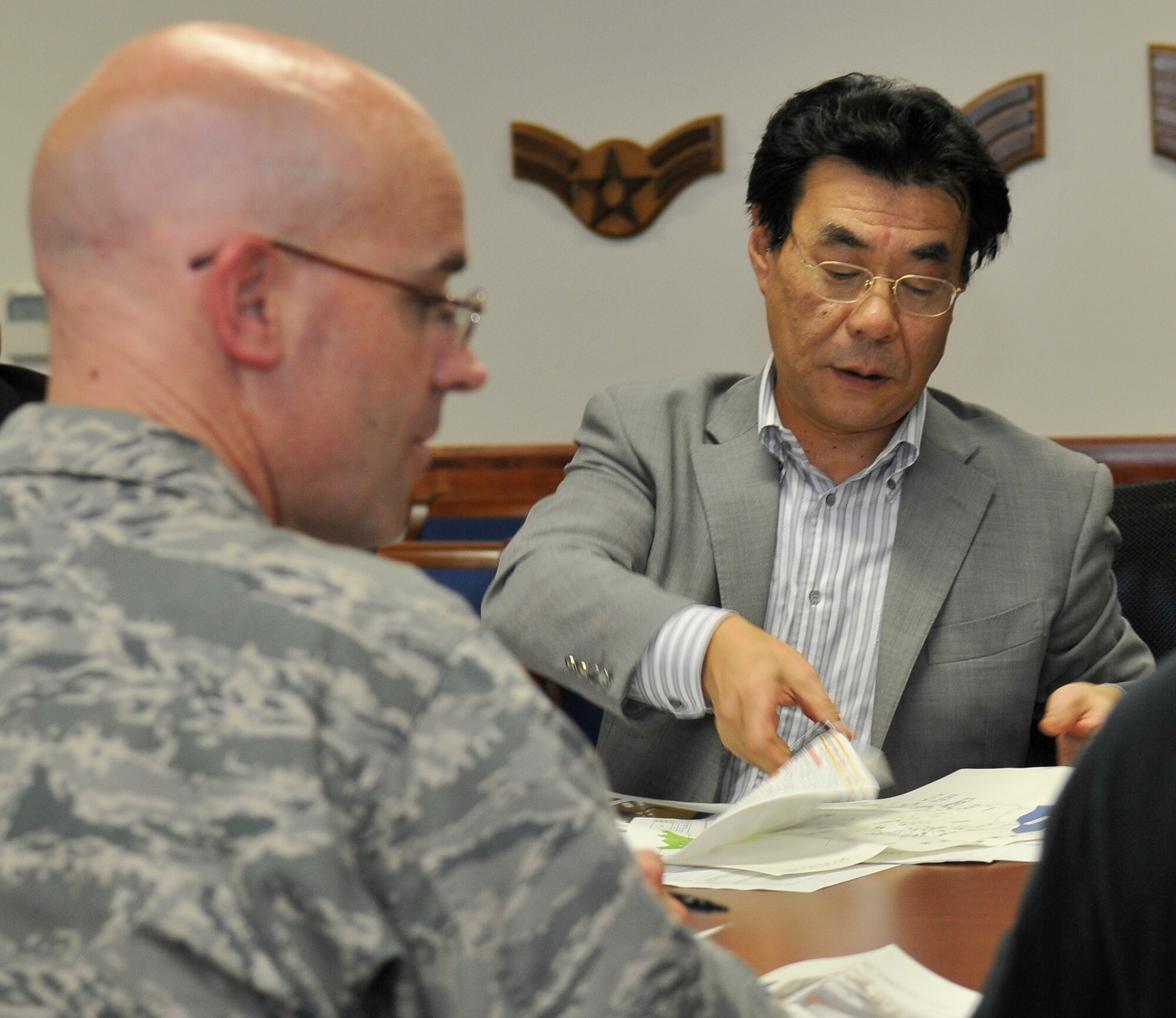 MISAWA AIR BASE, Japan – Mr. Tadashi Ozawa, Tohoku Electric Company Aomori Branch vice manager, removes a chart from a stack of papers to show Lt. Col. Dwayne Robison, 35th Civil Engineer Squadron commander, power usage trends for Misawa Air Base Aug. 31 in the 35 CES conference room here. Misawa’s self-imposed power budget of 85 percent is 15 percent less than the Government of Japan’s mandate for Misawa. Members from Tohoku Electric Company came to Misawa Air Base to praise base efforts in conserving power.  (U.S. Air Force photo/Tech. Sgt. Phillip Butterfield)

