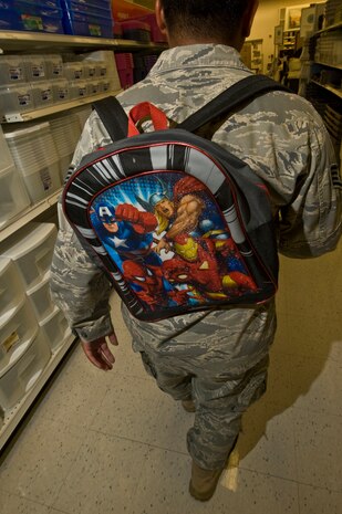 U.S. Air Force Airman walks through the commissary Aug. 25, 2011, at Nellis Air Force Base, Nev. The new Air Force Instruction 36-2903, which was revised July 18, 2011, states Airmen are not allowed to wear backpacks with any ornamentation, or high-gloss, designs, or hanging/dangling objects. The photo is staged and intended to provide a visual example of improper standards due to recent updates to AFI 36-2903, Dress and Personal Appearance of Air Force Personnel. (U.S. Air Force photo by Airman 1st Class Daniel Hughes/Released)