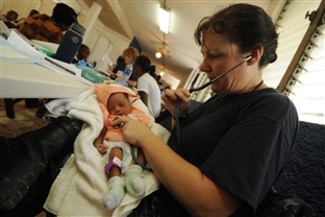 U.S. Navy Cmdr. Laurie Hale examines an infant at a temporary medical site at the Killick Coast Guard Base during Continuing Promise 2011 in Port-Au-Prince, Haiti, Aug. 28, 2011. Continuing Promise is a five-month humanitarian assistance mission to the Caribbean, Central and South America.