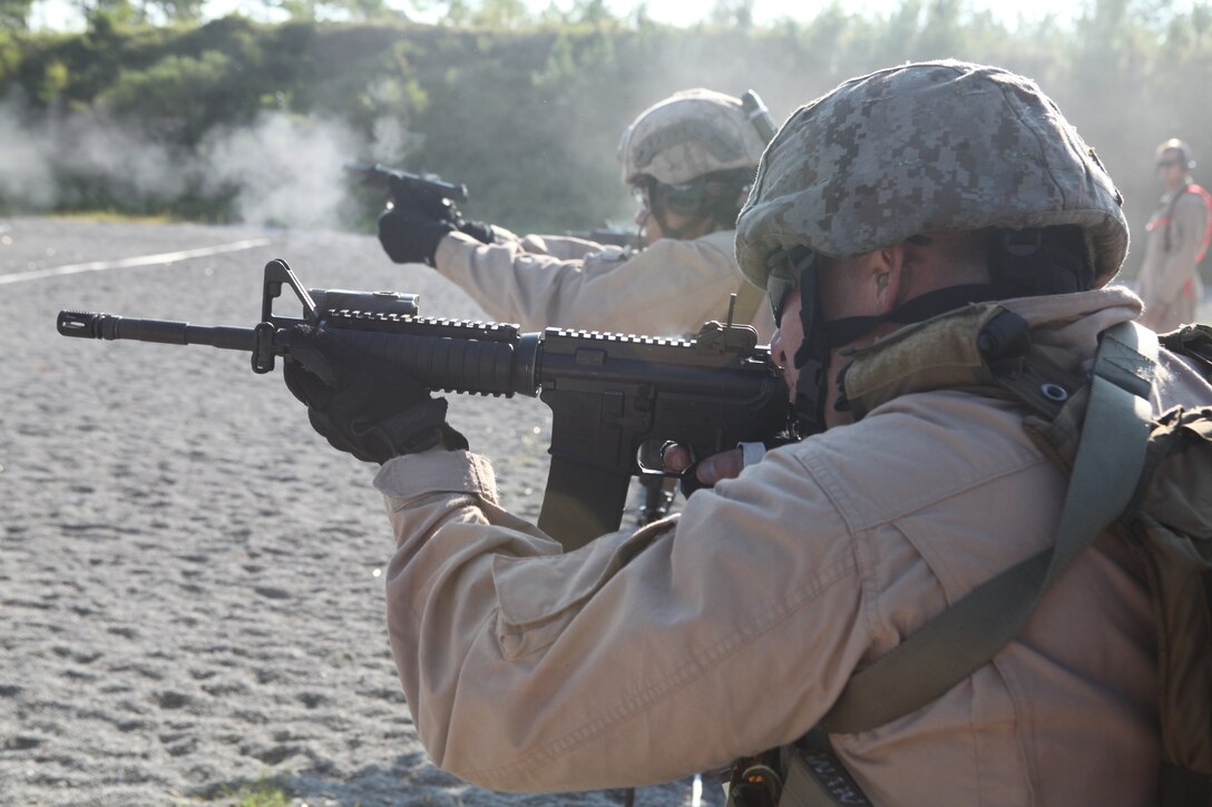 Marines fire their weapons during a timed drill as part of the Special Operations Training Group’s Close Quarters Tactics course Aug. 31, on Stone Bay’s Multi Purpose Range. The course is part of a pipeline of courses, conducted by SOTG, meant to prepare the Marines for the missions they may conduct while deployed with the 24th Marine Expeditionary Unit.