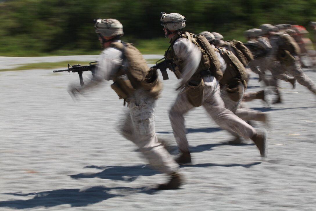 Marines dash 25-yards before firing in the stand and kneeling in 11 seconds during the Special Operations Training Group’s Close Quarters Tactics course Aug. 31, on Stone Bay’s Multi Purpose Range. The course is part of a pipeline of courses, conducted by SOTG, meant to prepare the Marines for the missions they may conduct while deployed with the 24th Marine Expeditionary Unit.